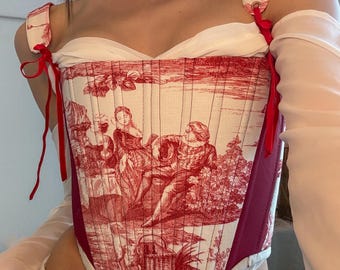May include: A red and white corset with a floral pattern. The corset has a sweetheart neckline and adjustable straps. The corset is made of a soft, comfortable fabric.