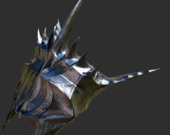 May include: A metallic silver helmet with sharp, pointed spikes and a textured surface. The helmet has a complex, angular design with a prominent central spike and a curved lower section, suggesting a fantasy or cosplay theme.