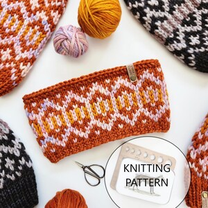 May include: A knitting pattern for a hat with a geometric design. The pattern includes yarn balls in orange, yellow, and pink. The pattern is printed on a white card with a wooden frame.