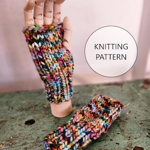 Könnte beinhalten: Ein Paar bunte gestrickte Fingerhandschuhe, präsentiert auf einer Holzhand. Die Handschuhe haben ein grobes Strickdesign mit einer Mischung aus leuchtenden Farben, darunter Rosa, Blau, Gelb und Grün. Der Text "KNITTING PATTERN" befindet sich in einem weißen Kreis.