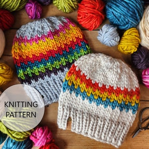 May include: Two knitted hats with rainbow stripes. The hats are made with chunky yarn and have a textured knit. The hats are surrounded by balls of yarn in various colors.