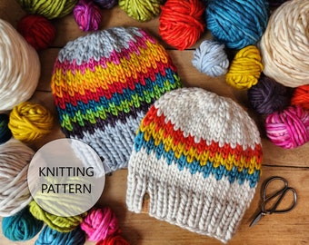 May include: Two knitted hats with rainbow stripes. The hats are made with chunky yarn and have a textured knit. The hats are surrounded by balls of yarn in various colors.