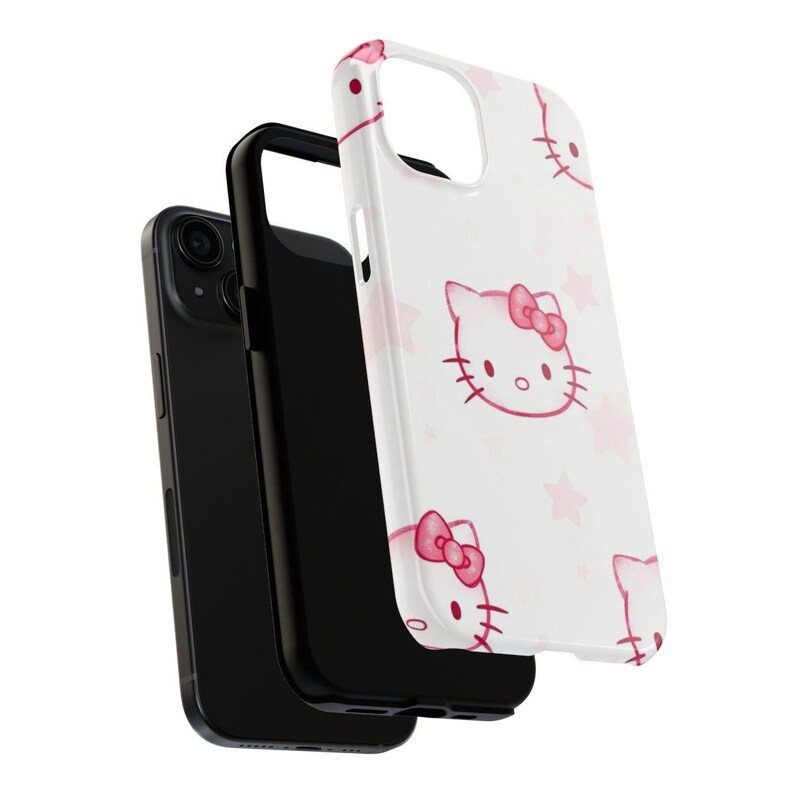 May include: A white phone case with a repeating pattern of pink Hello Kitty faces and stars. The case is displayed with a black phone and a black phone case.