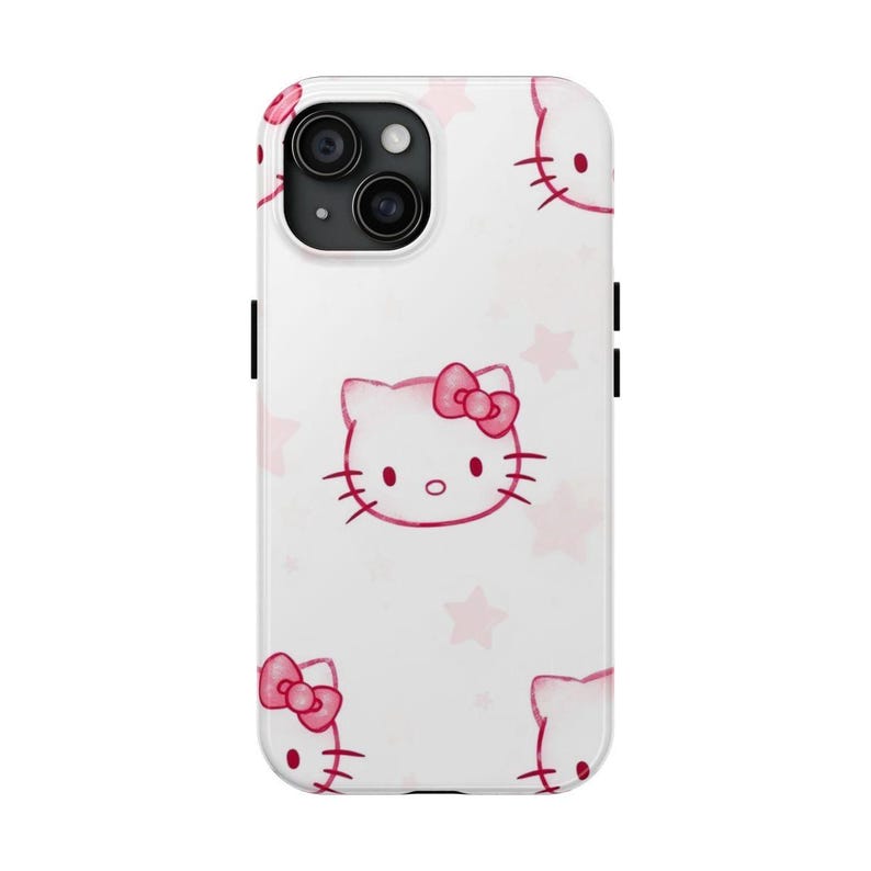 May include: White phone case with a repeating pattern of pink Hello Kitty faces and pink stars. The case has a camera cutout and black side buttons. A cute and playful accessory.