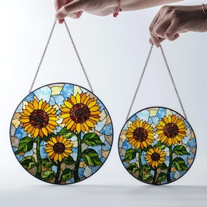 a pair of sunflowers hanging from a chain