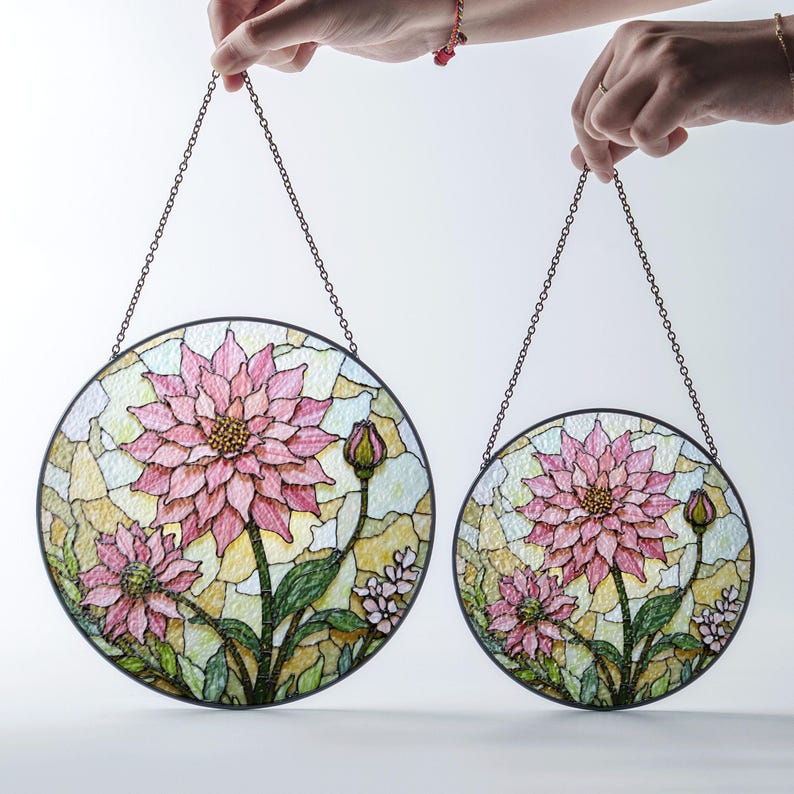 a hand holding a pair of stained glass flowers