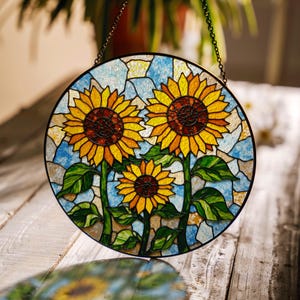 a stained glass sunflower is hanging from a chain