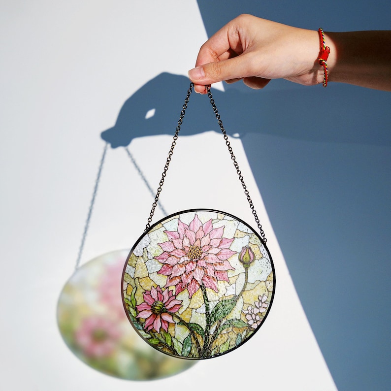 a hand holding a stained glass hanging decoration