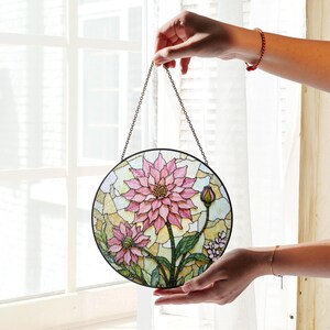 a hand holding a stained glass hanging decoration