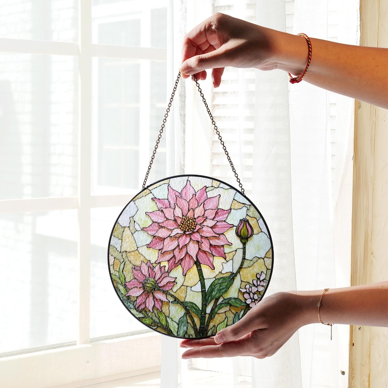 a hand holding a stained glass hanging decoration