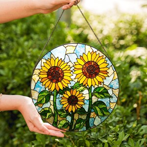 a hand holding a stained glass sunflower decoration