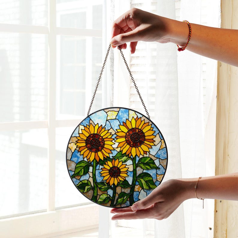 a hand holding a stained glass sunflower decoration