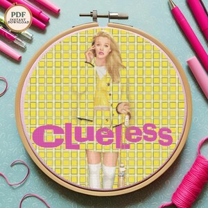 May include: Cross stitch pattern of a yellow and white checkered background with a woman in a yellow jacket and skirt. The word "Clueless" is written in pink letters.