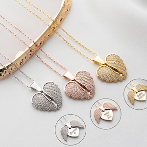 May include: Three silver necklaces with angel wing pendants. Each pendant is a heart shape with a different inscription. The inscription on the top pendant is "Forever in My Heart". The inscription on the middle pendant is "Always in My Thoughts". The inscription on the bottom pendant is "Loved and Remembered".