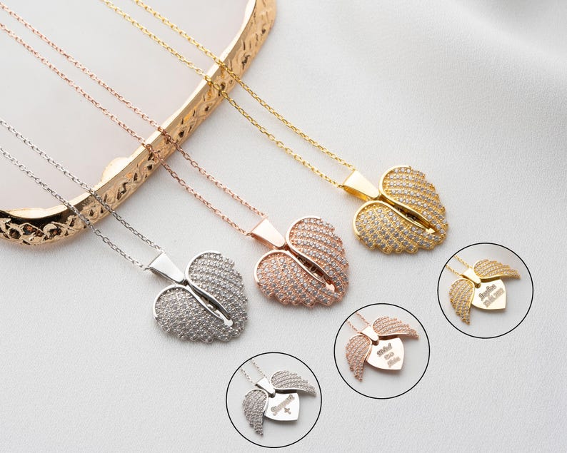 May include: Three silver necklaces with angel wing pendants. Each pendant is a heart shape with a different inscription. The inscription on the top pendant is "Forever in My Heart". The inscription on the middle pendant is "Always in My Thoughts". The inscription on the bottom pendant is "Loved and Remembered".