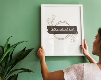 May include: A white framed print with a black and white design featuring the text "Alhamdulillah" in a circle with floral accents.