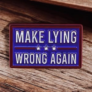 Puede incluir: Un pin rectangular con fondo azul y el texto blanco "MAKE LYING WRONG AGAIN". El pin tiene un borde rojo y tres estrellas blancas. El pin está sobre un fondo de madera.