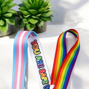 Lanière arc-en-ciel avec drapeau de la fierté LGBTQ Progress avec clip à boucle amovible, fixation pour téléphone portable et système de sécurité - Y compris sensibilisation, Ally