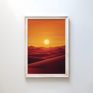 May include: Framed print depicting a desert sunset. The artwork showcases a fiery orange and yellow sky with a prominent sun. The foreground reveals undulating red sand dunes, creating a warm and inviting scene.