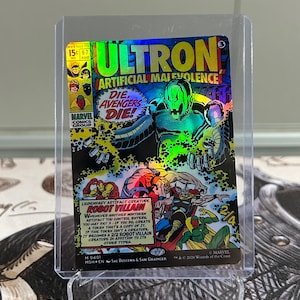 May include: A holographic trading card featuring Ultron from Marvel Comics. The card displays the text ULTRON ARTIFICIAL MALEVOLENCE, DIE AVENGERS DIE, and ROBOT VILLAIN. It shows a metallic robot figure and comic book art of Iron Man, Thor, and Vision.