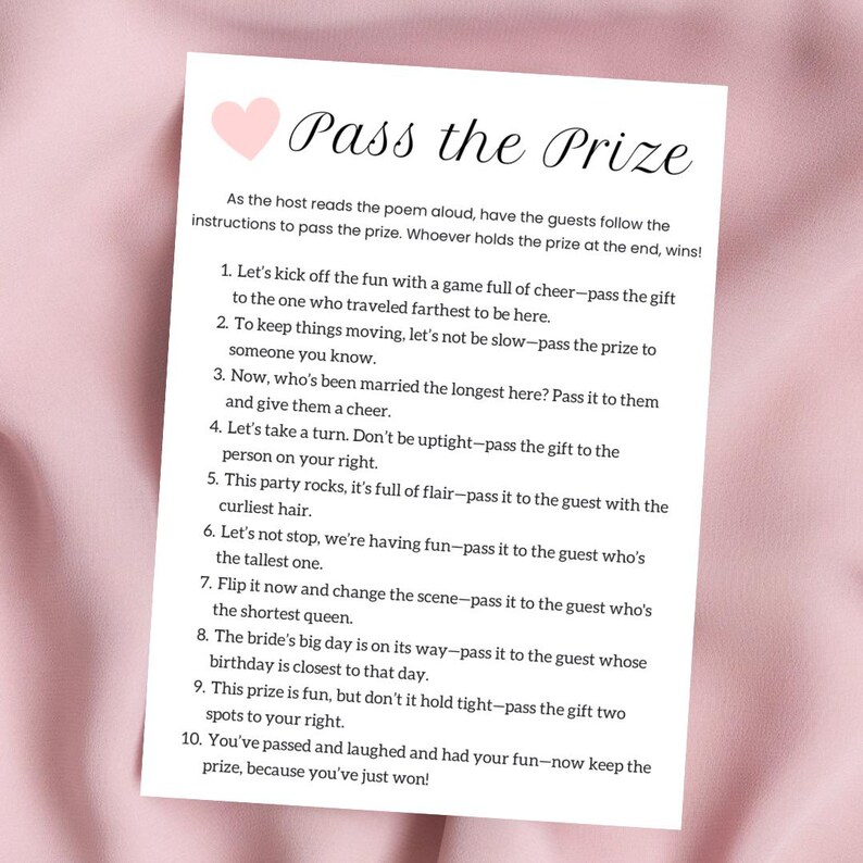 May include: A pink card with the title "Pass the Prize" and instructions for a game where guests pass a prize around based on different criteria. The instructions are written in a playful, rhyming style.