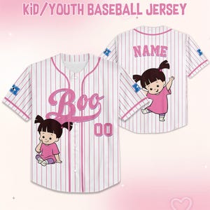 K&ouml;nnte beinhalten: Wei&szlig;-rosa gestreiftes Baseball-Trikot mit dem Wort "Boo" in rosa Schrift. Das Trikot zeigt eine Cartoon-Figur und die Nummer "00". Auf der R&uuml;ckseite des Trikots steht das Wort "Name" in rosa Schrift und eine Cartoon-Figur.