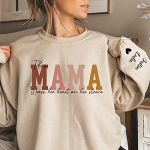 Custom This Mama Wears Her Heart On Her Sleeve Sweatshirt, Personalized Mom Sweatshirt With Kids Names, Cute Momma Outfit, Mothers Day Gifts