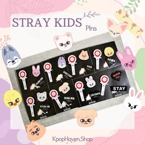 Puede incluir: Un conjunto de pines de Stray Kids con los nombres e imágenes de los miembros de la banda. Los pines están sobre un fondo negro con un borde blanco. Los pines son de diferentes formas y tamaños. Los pines son todos de metal y tienen un acabado brillante.