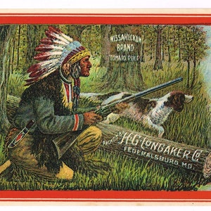 May include: A vintage label for Wissahickon Brand Tomato Pulp. The label features a red diamond with the words "Tomato Pulp" in white. The label also features a Native American man in a feathered headdress hunting with a rifle and a dog. The label text reads "Wissahickon Brand Tomato Pulp", "Contents 10 ounces", "Made from Tomatoes and Tomato Trimmings", and "H.G. Longaker Co. Federalburg, Md."