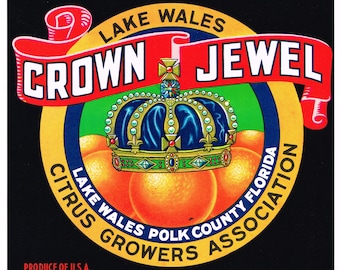 May include: A yellow and gold circular label with the text "Crown Jewel" in a red banner, "Lake Wales Citrus Growers Association" in a black banner, and "Lake Wales Polk County Florida" in a white banner. The label also features a blue and gold crown with red jewels and three orange citrus fruits.