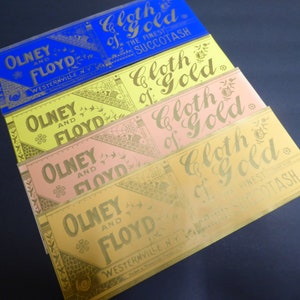 May include: Four vintage labels with gold lettering on different colored backgrounds. The labels read "Olney and Floyd Cloth of Gold" and "The Finest Succotash".