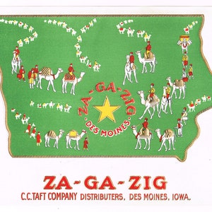 May include: A green and gold illustration of a camel caravan with the text "ZA-GA-ZIG DES MOINES" in a circle. The text "ZA-GA-ZIG C.C. TAFT COMPANY DISTRIBUTERS, DES MOINES, IOWA." is below the illustration.