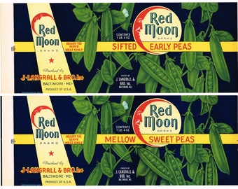 May include: Two vintage Red Moon brand canned pea labels. The top label is for sifted early peas and the bottom label is for mellow sweet peas. Both labels feature a red crescent moon with a face and green pea pods on a dark blue background.