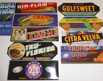 May include: A collection of vintage citrus fruit crate labels. The labels feature colorful designs and text, including "Bull Frog," "Air-Flow," "Crane," "Kiss-Me," "Tru-Florida," "Haynes," "Gulfsweet," "Merrymaker," "Citra Velva," and "Tropic Gold."