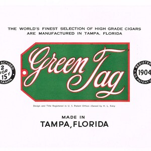 May include: A vintage advertisement for Green Jag cigars, manufactured in Tampa, Florida. The ad features a green and red tag with the brand name in white script. The text "2 for 15¢" is visible in a black circle.
