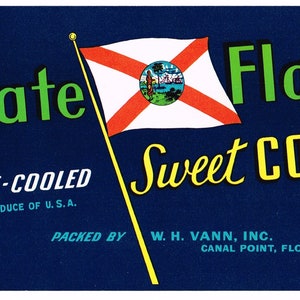 May include: A blue and yellow label with the text "State Flag Sweet CORN" and a depiction of the Florida state flag. The label also includes the text "PRE-COOLED PRODUCE OF U.S.A. PACKED BY W. H. VANN, INC. CANAL POINT, FLORIDA."
