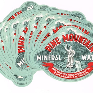 Puede incluir: Un montón de 12 etiquetas vintage para agua mineral Pine Mountain. Las etiquetas son de color azul claro con texto rojo y negro. Las etiquetas presentan una escena de montaña con una mujer sosteniendo una jarra y una cascada. El texto en las etiquetas dice "Pine Mountain Mineral Water" y "Pine Mountain Mineral Springs Co. Cloverdale, California."