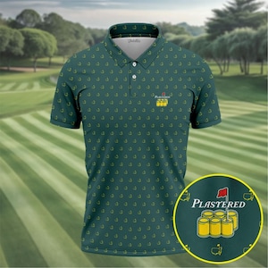 Puede incluir: Polo verde con un patrón repetido de banderas de golf amarillas. La camisa tiene una tapeta de tres botones y un pequeño logotipo "PLASTERED" con un diseño de bandera de golf. El fondo muestra un campo de golf.