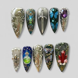 May include: A collection of ten fantasy-themed nail art designs. The designs include silver filigree, stained glass, a sword, blue butterflies, a purple gem, a fleur-de-lis, a potion bottle, and crystals with mushrooms.