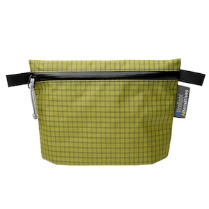 Könnte beinhalten: Eine limettengrüne Reißverschlusstasche mit schwarzem Karomuster. Die Tasche hat einen schwarzen horizontalen Reißverschluss, schwarze seitliche Laschen und einen grauen Kordelzug. Ein graues Stoffetikett an der Seite zeigt den Text Ultralight Alternatives.