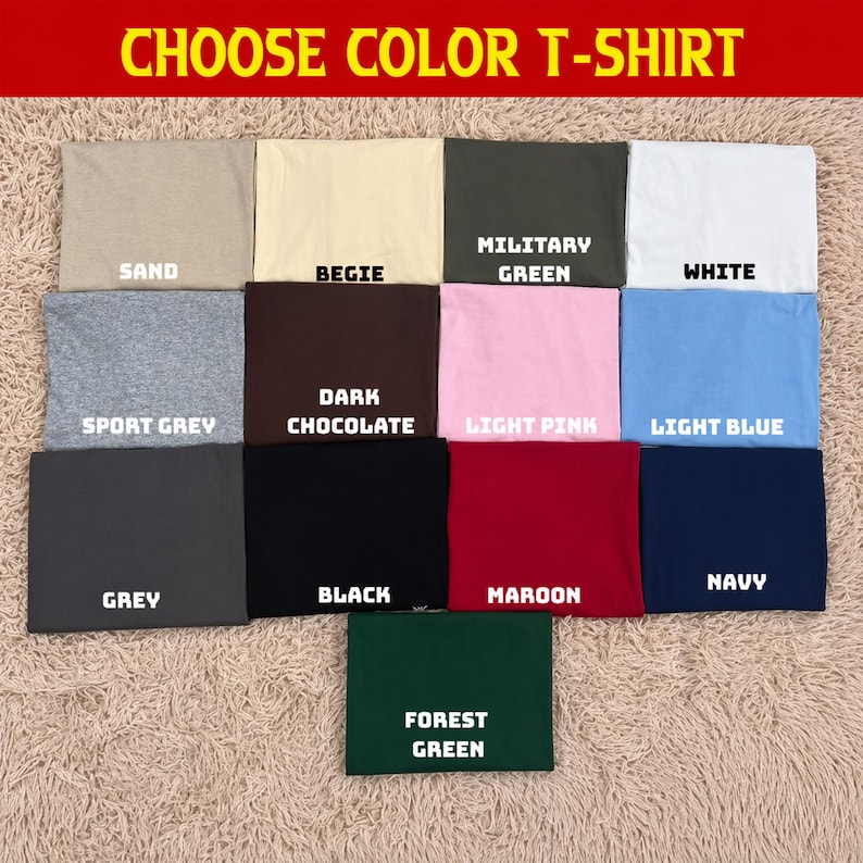 Pode incluir: Uma sele&ccedil;&atilde;o de camisetas dobradas em v&aacute;rias cores, incluindo areia, bege, verde militar, branco, cinza desportivo, chocolate escuro, rosa claro, azul claro, cinza, preto, bord&ocirc;, azul marinho e verde floresta. O texto "CHOOSE COLOR T-SHIRT" est&aacute; no topo.