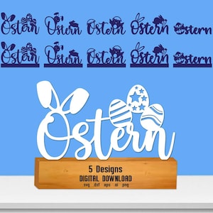 May include: A white Easter-themed wooden sign with the word "Ostern" and Easter eggs. The sign sits on a wooden base. The image also shows several other Easter-themed designs in blue.