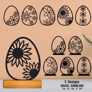 May include: Black laser-cut Easter egg designs with floral patterns. The image shows five different designs, including a large egg on a wooden base. The text "5 Designs DIGITAL DOWNLOAD" is at the bottom.