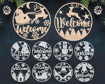 Puede incluir: Colección de adornos navideños de madera cortados con láser con la palabra "Bienvenido". Los diseños incluyen a Papá Noel en trineo, renos, copos de nieve, árboles de Navidad, un muñeco de nieve y un hombre de jengibre. Los adornos son circulares.
