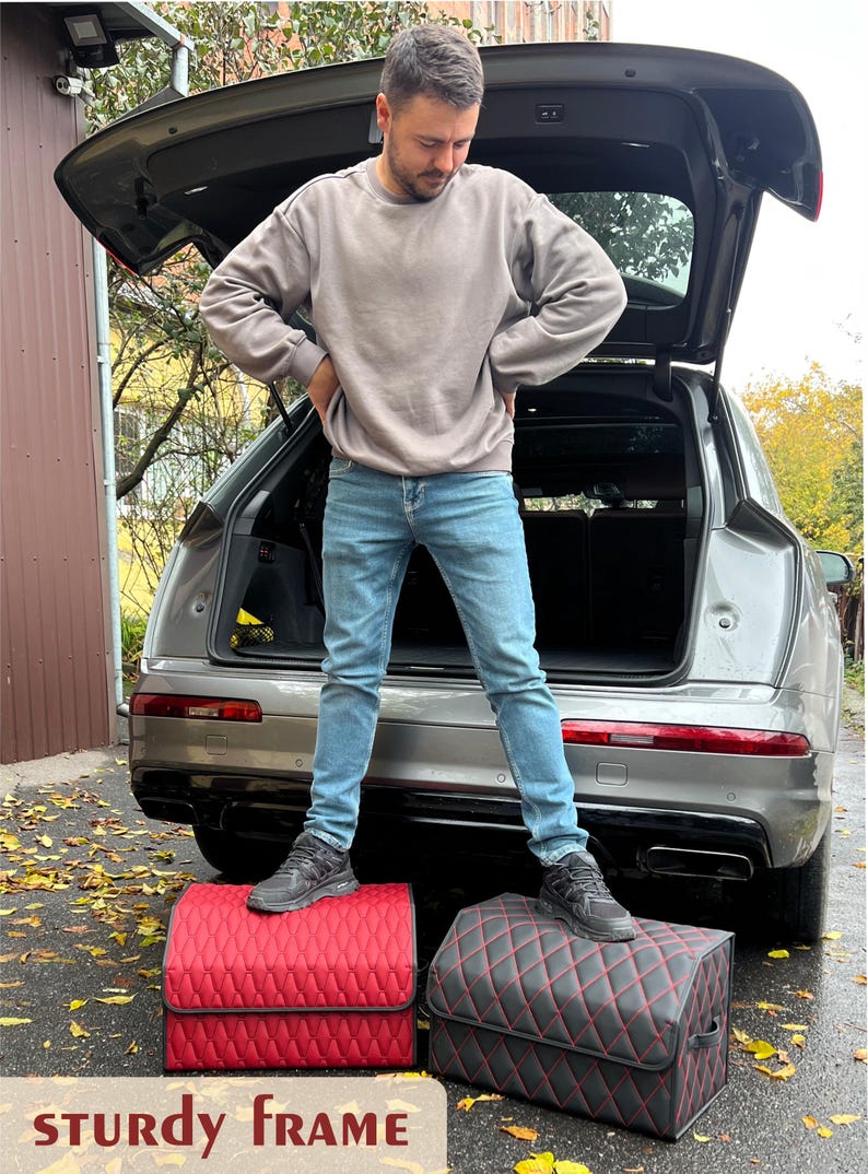 May include: Two car trunk organizers with a diamond-stitched pattern. One is red with black trim, and the other is black with red trim. The text "STURDY FRAME" is at the bottom of the image. A person is standing on top of the organizers.