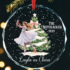 May include: Round glass Christmas ornament with a red ribbon. The ornament features a ballerina in a white dress, a Christmas tree, and the text "The Nutcracker 2025" and "Layla as Clara".