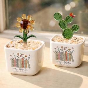 May include: Two small white square planters, one with a glass sunflower and the other with a glass cactus. Each planter has a floral design and the text "Mrs. Natalia, School Counselor."