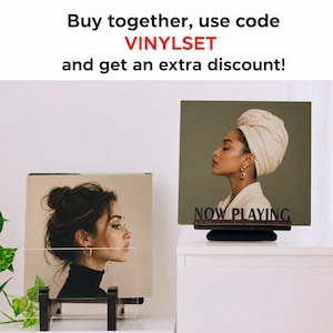 May include: Two vinyl record display stands holding album covers. One stand is clear acrylic, the other is dark wood with the text "NOW PLAYING" in black. The text "Buy together, use code VINYLSET and get an extra discount!" is at the top.