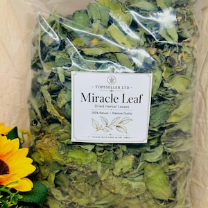 May include: A clear plastic bag filled with dried green herbal leaves, featuring a white rectangular label printed with Topeseller Ltd. Miracle Leaf, 100% Natural, Premium Quality, and Packed with care in Sri Lanka, alongside a yellow flower.