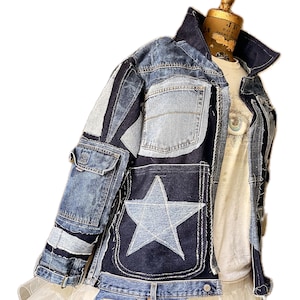 May include: A blue denim jacket with a large star patch on the back. The jacket is made of different pieces of denim sewn together, creating a patchwork effect.